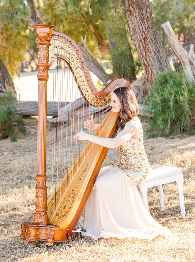 Harpist for weddings, wearing a champagne dress at an outdoor wedding ceremony